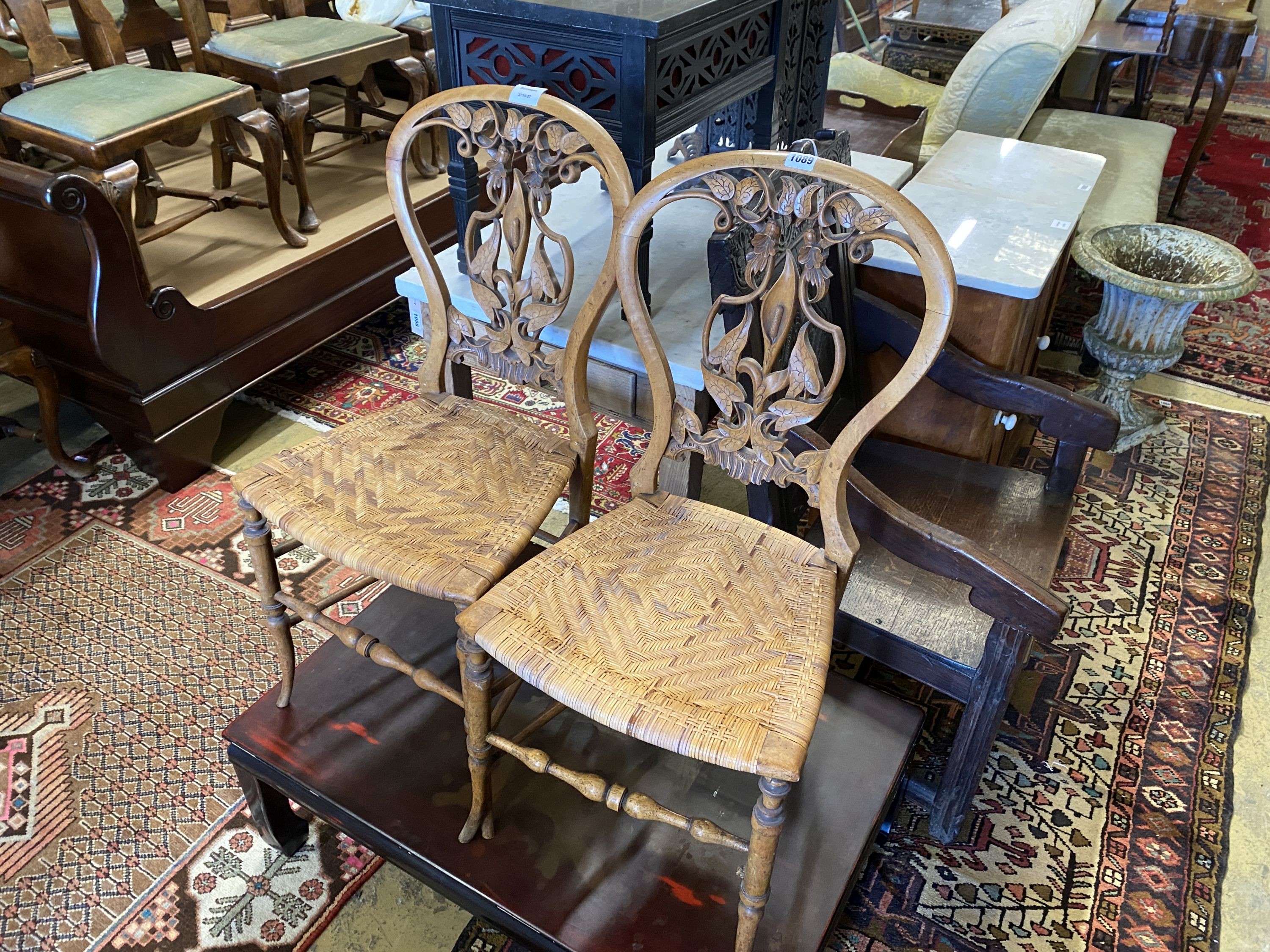 A pair of Victorian floral carved walnut cane seated side chairs